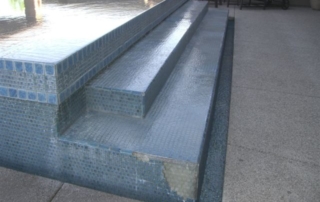 After: pool steps and wall resurfaced in blue glass tile