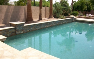 After: remodeled pool with a stacked-stone raised wall and new decking