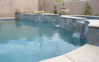 After: remodeled pool with a slate-tile raised wall and spillways