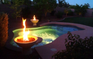 Spool lit at night with fire bowls