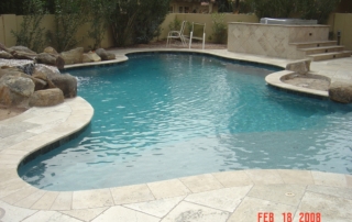 DSC00134 Freeform pool with a boulder edge, travertine decking and a raised spa beyond