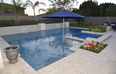 Pool with a sun shelf umbrella, raised planter and travertine decking