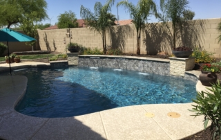 19 Freeform pool with raised stone-wall spillways and palm trees
