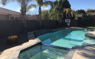 Remodeled pool and attached spa with new interior finish and dark tile trim
