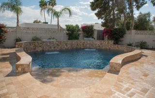 5after Pool with a curved stacked-stone raised wall and travertine decking