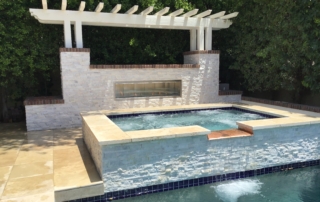 9after Raised spa with a stacked-stone wall and pergola, spilling into the pool