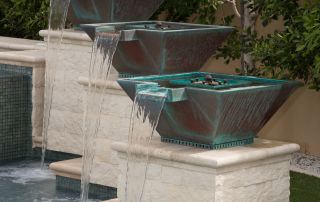 IBK_4322 Three copper water bowls on stone pedestals spilling into the pool