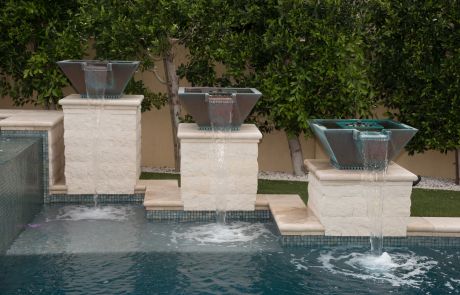 Three water bowls on pedestals pouring into the pool