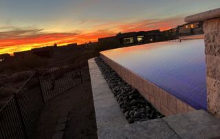IMG_4267 Vanishing-edge pool wall with a river-rock basin at sunset