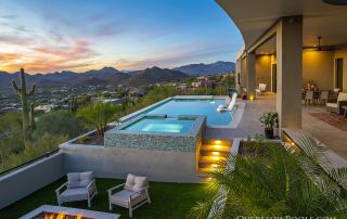 Overflow Pools Hillside pool and raised spa with lit steps overlooking the mountains at sunset